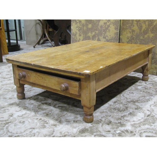 1149 - A Victorian low stripped pine table of rectangular form with frieze drawer raised on turned supports... 