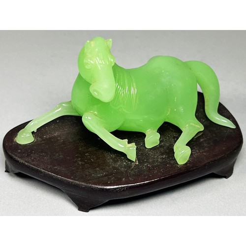 412 - A vintage jade coloured Chinese Peking glass horse, recumbent on hardwood base