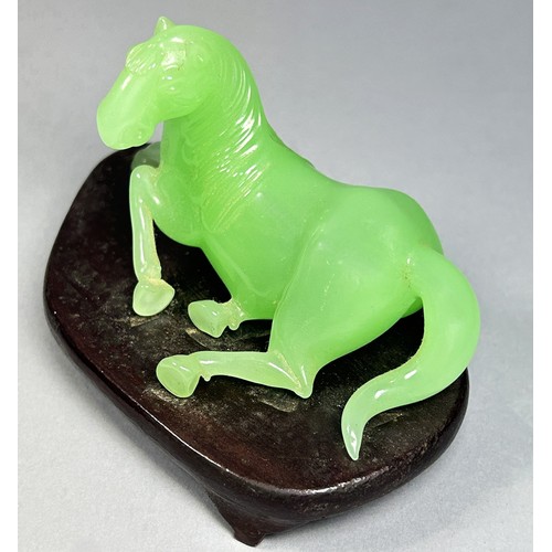 412 - A vintage jade coloured Chinese Peking glass horse, recumbent on hardwood base