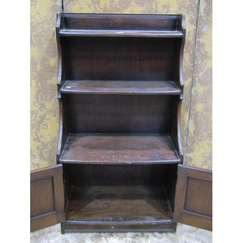 1158 - A vintage Ercol dark stained elm dwarf waterfall type bookcase partially enclosed by a pair of panel... 