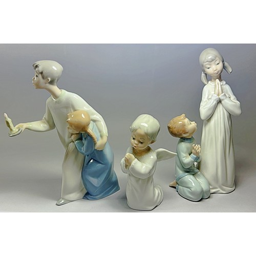 99 - A collection of Lladro figure groups of children in their nightgowns in various poses to include a b... 