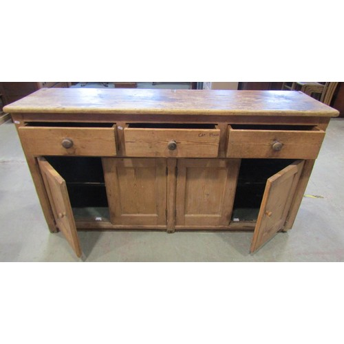 1189 - A Victorian stripped pine kitchen dresser base enclosed by four panelled doors beneath three frieze ... 