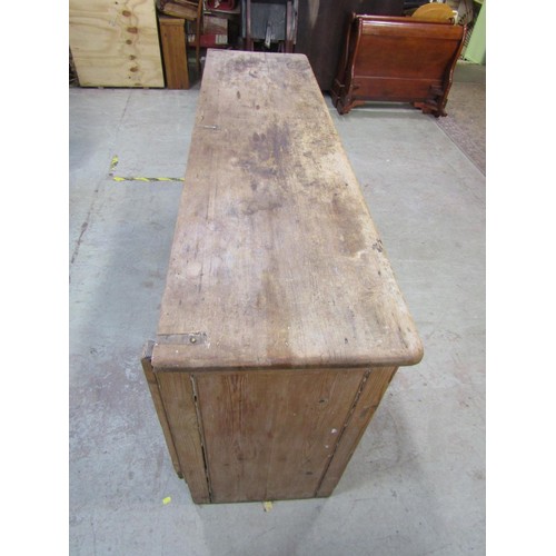 1189 - A Victorian stripped pine kitchen dresser base enclosed by four panelled doors beneath three frieze ... 