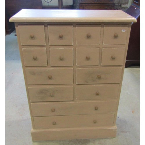 1195 - A painted pine chest fitted with an arrangement of fourteen drawers with turned handles 113 cm high ... 