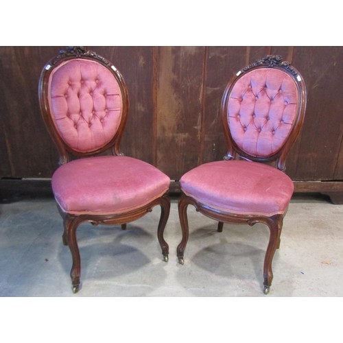 1198 - A pair of Victorian chairs with upholstered seats and buttoned cameo shaped backs within walnut show... 