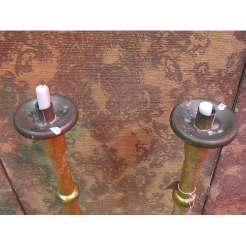 1200 - A pair of gilt wood  candlestands with turned stems and stepped disc shaped bases, 103 cm high