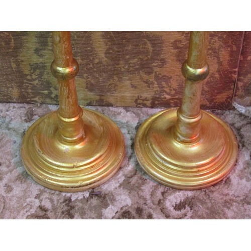 1200 - A pair of gilt wood  candlestands with turned stems and stepped disc shaped bases, 103 cm high