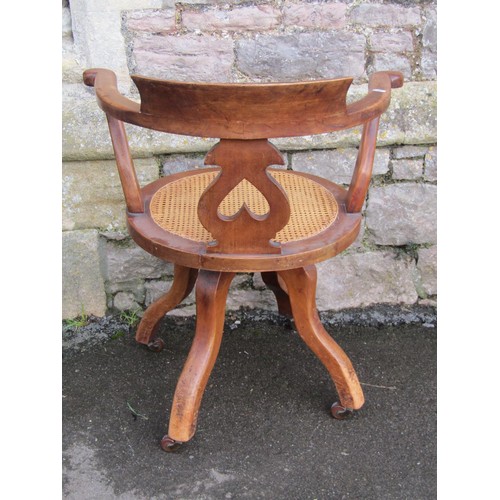 1288 - A late Victorian swivel office chair with pierced splat and cane panelled seat