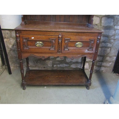 1308 - A small oak cottage dresser in the Jacobean style, with open plate rack over two drawers, on turned ... 