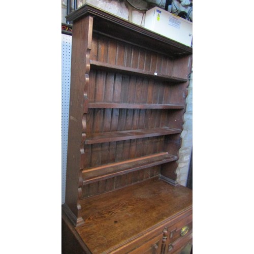 1308 - A small oak cottage dresser in the Jacobean style, with open plate rack over two drawers, on turned ... 