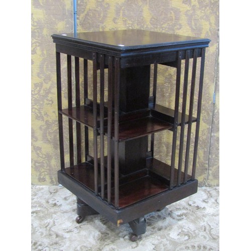 1311 - An Edwardian mahogany floorstanding revolving bookcase of square cut form, 85cm high x 46cm square