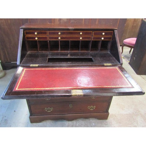 1218 - A Georgian mahogany bureau, the fall flap enclosing a partially fitted interior of small drawers and... 