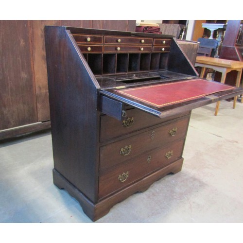 1218 - A Georgian mahogany bureau, the fall flap enclosing a partially fitted interior of small drawers and... 