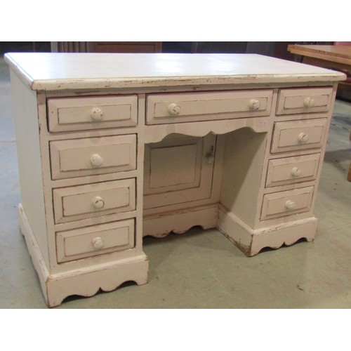 1219 - A  pine kneehole desk fitted with an arrangement of nine drawers flanking a recessed cupboard with a... 