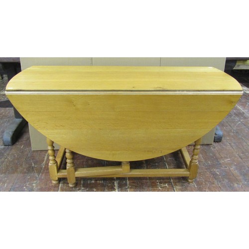 1330 - A large light oak old English style oval drop leaf dining table with gateleg action, raised on eight... 