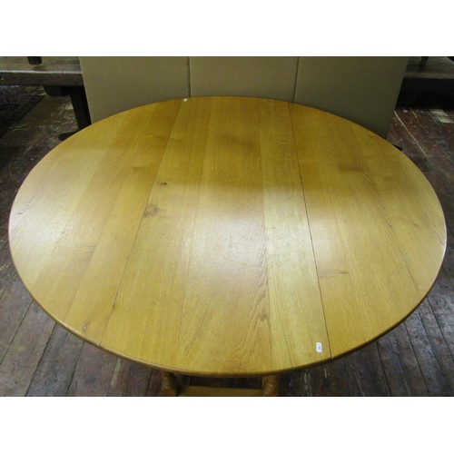 1330 - A large light oak old English style oval drop leaf dining table with gateleg action, raised on eight... 