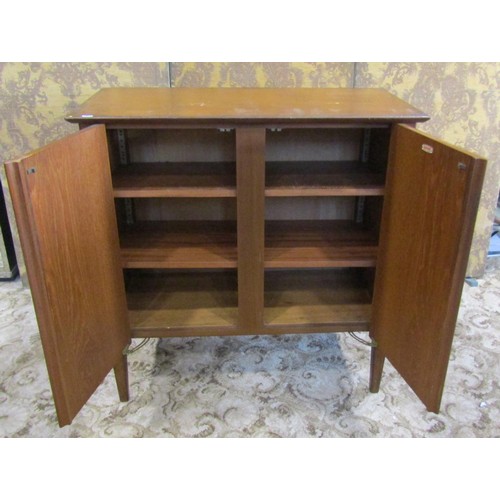 1230 - A mid century teak office side cupboard enclosed by a pair of rectangular doors, with shelved interi... 