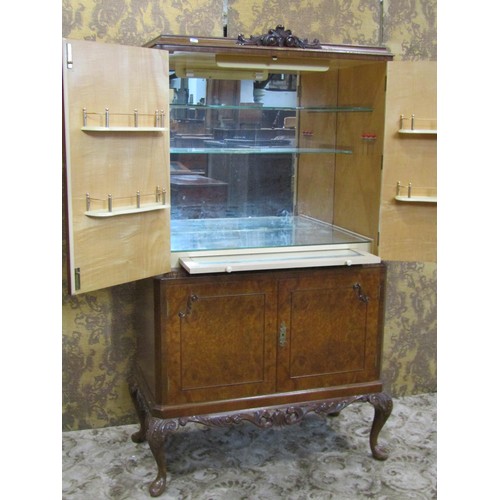 1242 - A figured and burr walnut veneered cocktail cabinet, freestanding and enclosed by four doors with de... 