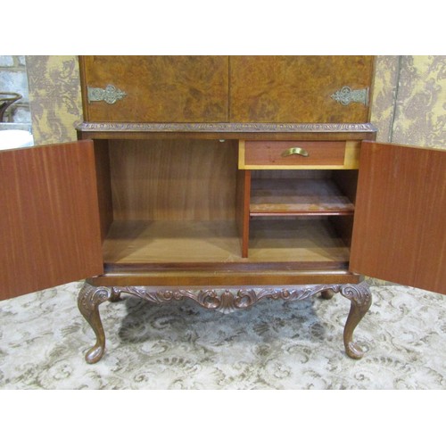 1242 - A figured and burr walnut veneered cocktail cabinet, freestanding and enclosed by four doors with de... 