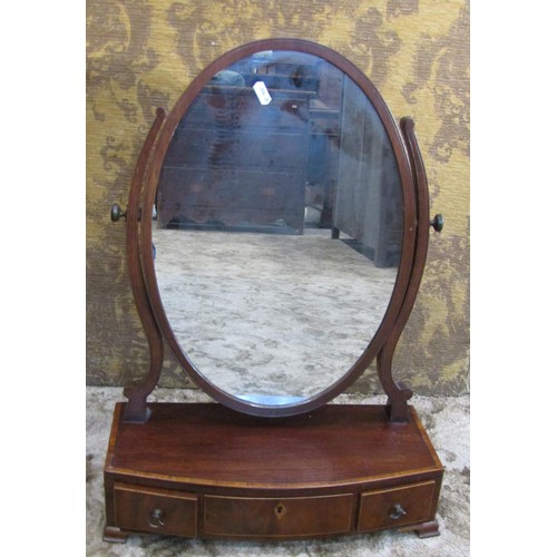 1250 - A small early 19th century mahogany toilet mirror of oval form raised on a bow fronted box base with... 