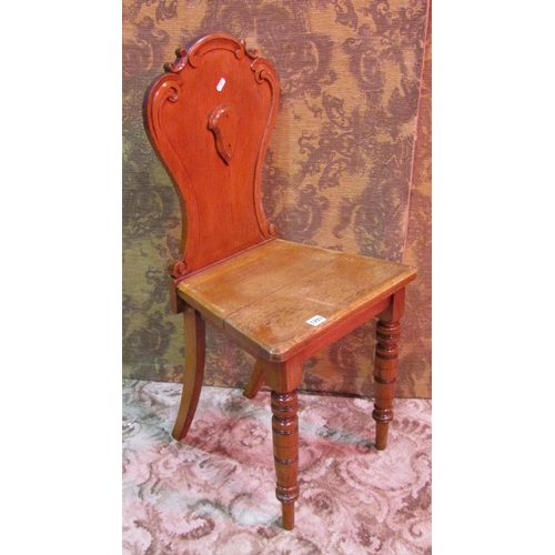 1256 - A Victorian oak hall chair with carved and moulded shield shaped back and raised on turned tapered f... 