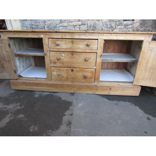 1373 - A substantial Victorian stripped and waxed pine dresser base, partially enclosed by a pair of panell... 