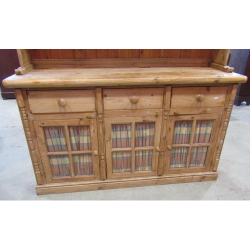 1223 - A stripped pine farmhouse kitchen dresser, the base partially enclosed by three glazed quarter panel... 