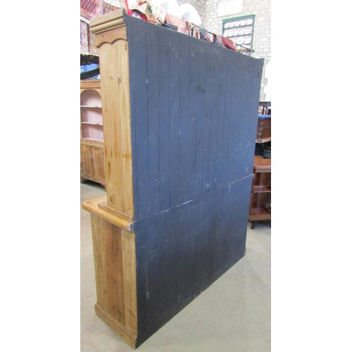 1223 - A stripped pine farmhouse kitchen dresser, the base partially enclosed by three glazed quarter panel... 