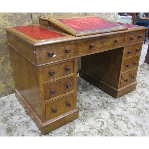 1255 - A Victorian oak Dickens type kneehole twin pedestal desk with inset leather panelled top, over an ar... 