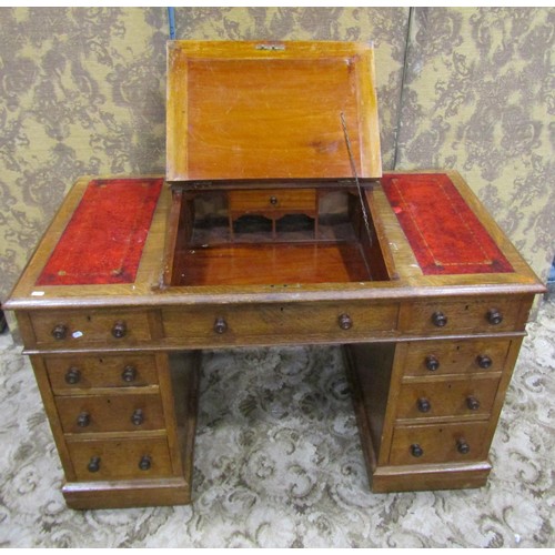 1255 - A Victorian oak Dickens type kneehole twin pedestal desk with inset leather panelled top, over an ar... 