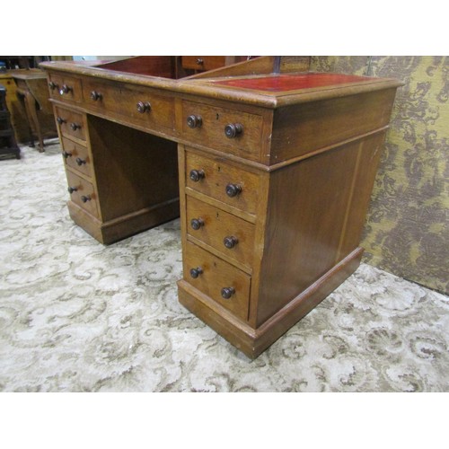 1255 - A Victorian oak Dickens type kneehole twin pedestal desk with inset leather panelled top, over an ar... 