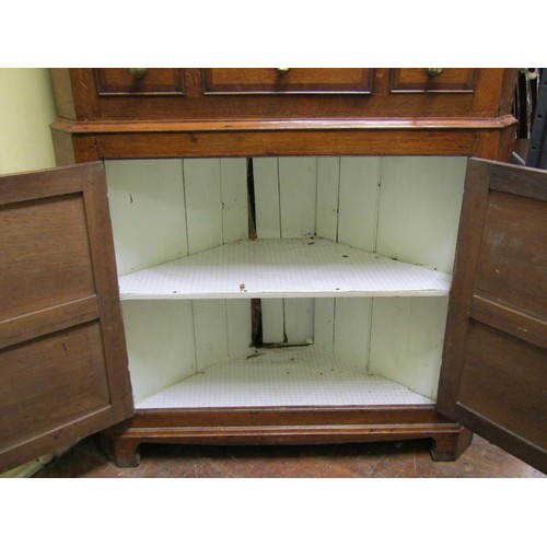 1392 - A Georgian oak two sectional free standing corner cupboard of North Welsh origin, enclosed by two pa... 