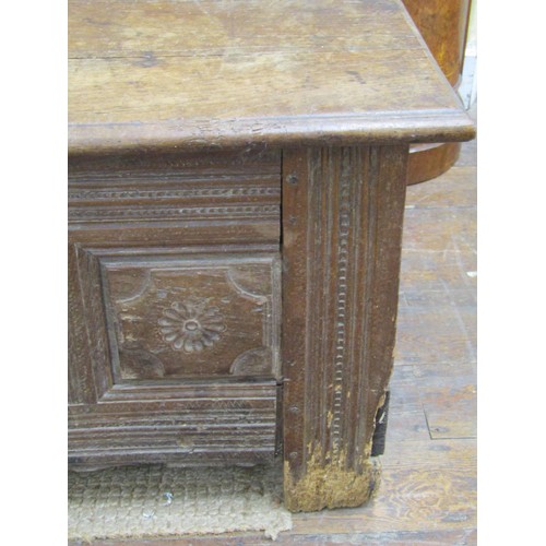 1395 - An early oak paneled coffer, the front elevation enclosing repeating floral detail within moulded st... 