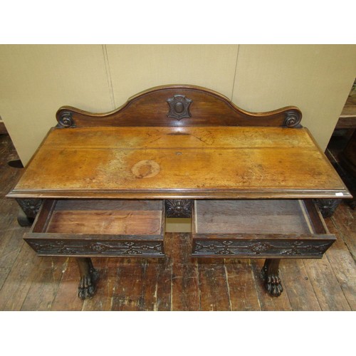 1415 - A Victorian oak hall table raised on shaped supports with lions paw feet, the carved frieze enclosin... 