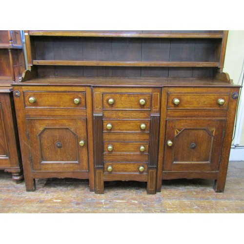 1427 - A Georgian Welsh oak breakfront dresser, the T shaped arrangement of six drawers flanked by two cupb... 