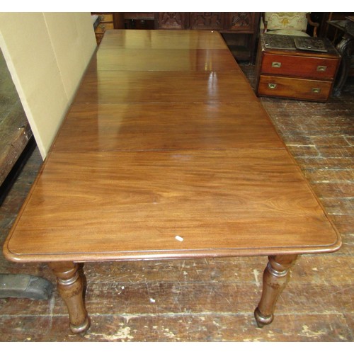 1447 - An early Victorian period mahogany extending dining table raised on four turned supports, with three... 