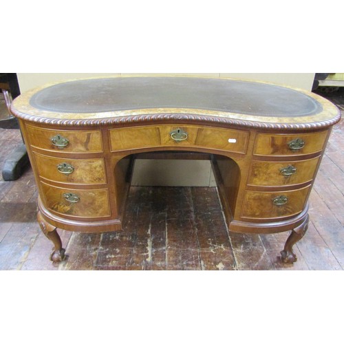 1451 - An Edwardian walnut and figured walnut ladies kidney shaped writing desk, enclosing seven drawers on... 