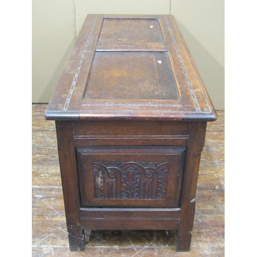 1453 - An old English panelled oak coffer with rising lid, the front elevation with repeating geometric det... 