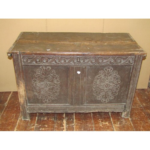 1454 - An 18th century panelled oak coffer the front elevation with geometric carved detail, 66cm high x 10... 