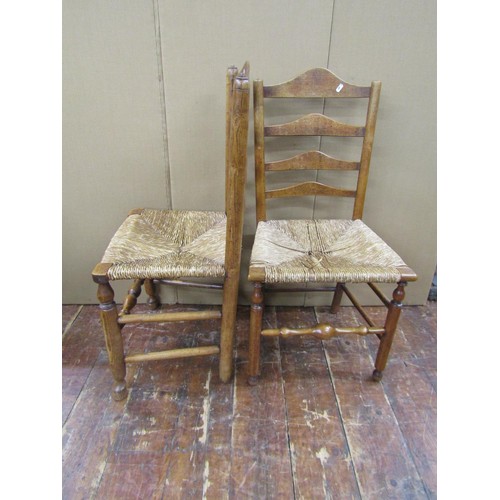 1473 - A collection of five Georgian ashwood country made ladderback chairs on turned supports with rush se... 