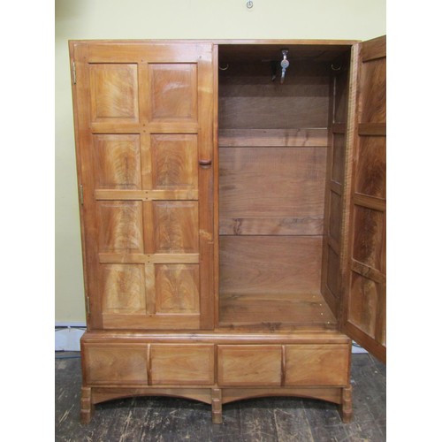 1482 - A fine quality Cotswold school fitted wardrobe in pale English walnut, the paneled frame enclosed by... 