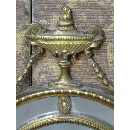 1363 - An Edwardian oval gilt framed wall mirror in the Georgian style with flaming urn, trailing harebell ... 