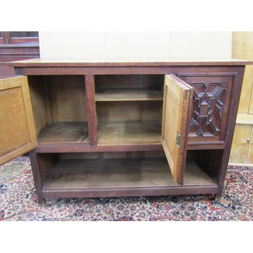 1432 - An Edwardian oak buffet in the Jacobean style enclosed by three panelled doors with open shelf below... 