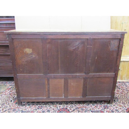 1432 - An Edwardian oak buffet in the Jacobean style enclosed by three panelled doors with open shelf below... 