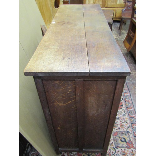 1432 - An Edwardian oak buffet in the Jacobean style enclosed by three panelled doors with open shelf below... 