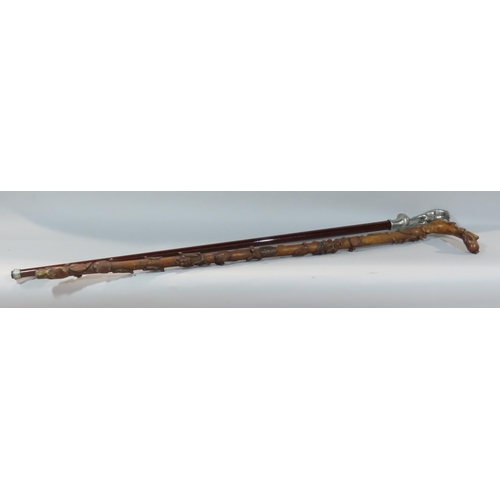 540 - An Art Deco walking stick with a gymnastic naked female handle, and another stick with floral carved... 