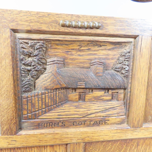 491 - An early 20th century oak fire screen with a thatched cottage carved to a panel, together with a tie... 