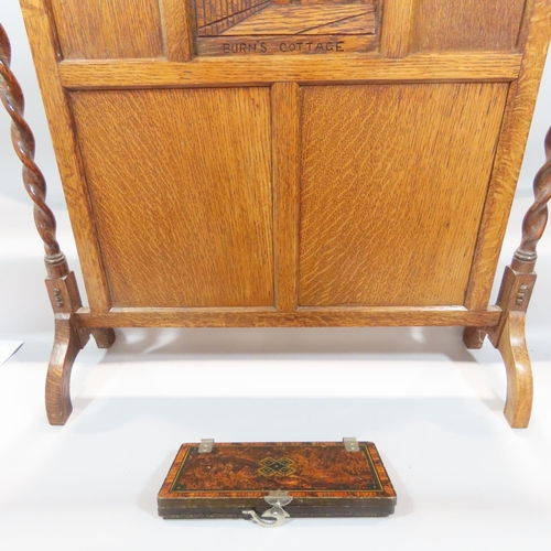 491 - An early 20th century oak fire screen with a thatched cottage carved to a panel, together with a tie... 