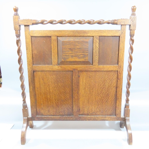 491 - An early 20th century oak fire screen with a thatched cottage carved to a panel, together with a tie... 