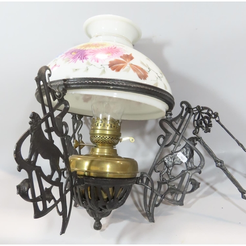 493 - A Victorian cast iron black adjustable hanging oil lamp with a floral glass shade.